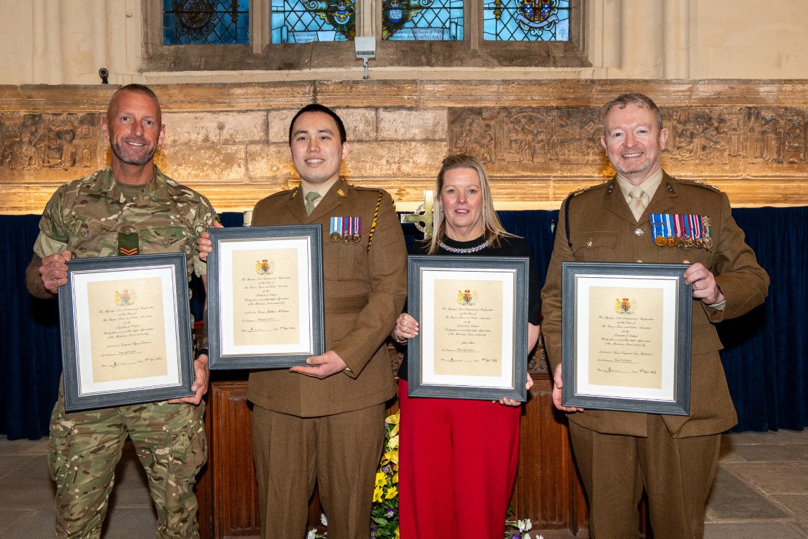 A group of award recipients with their certificates at Paisley Abbey