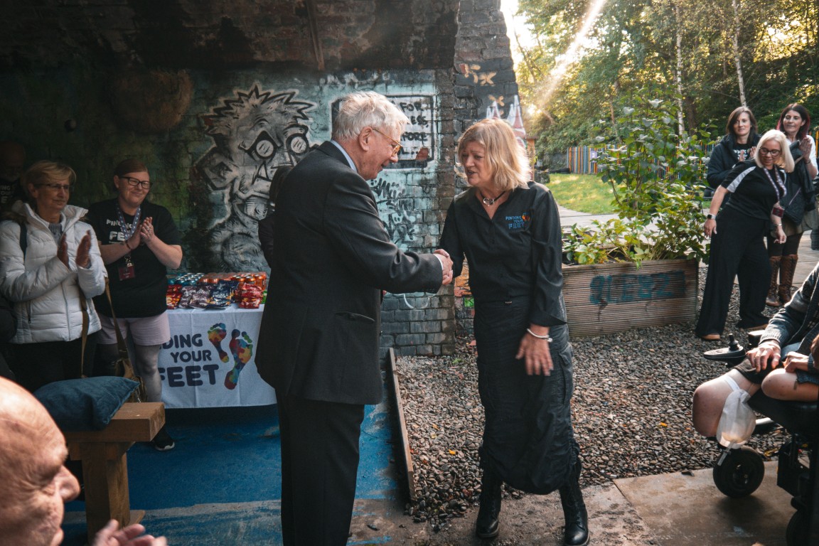 The Duke of Gloucester greets a woman in the garden