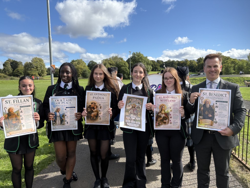 Pupils holding posters about patron saints at Pilgrims in the Park