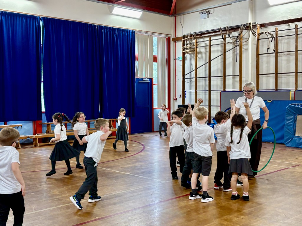 Pupils taking part in a physical activity session in the school hall at Bridge of Weir Primary School