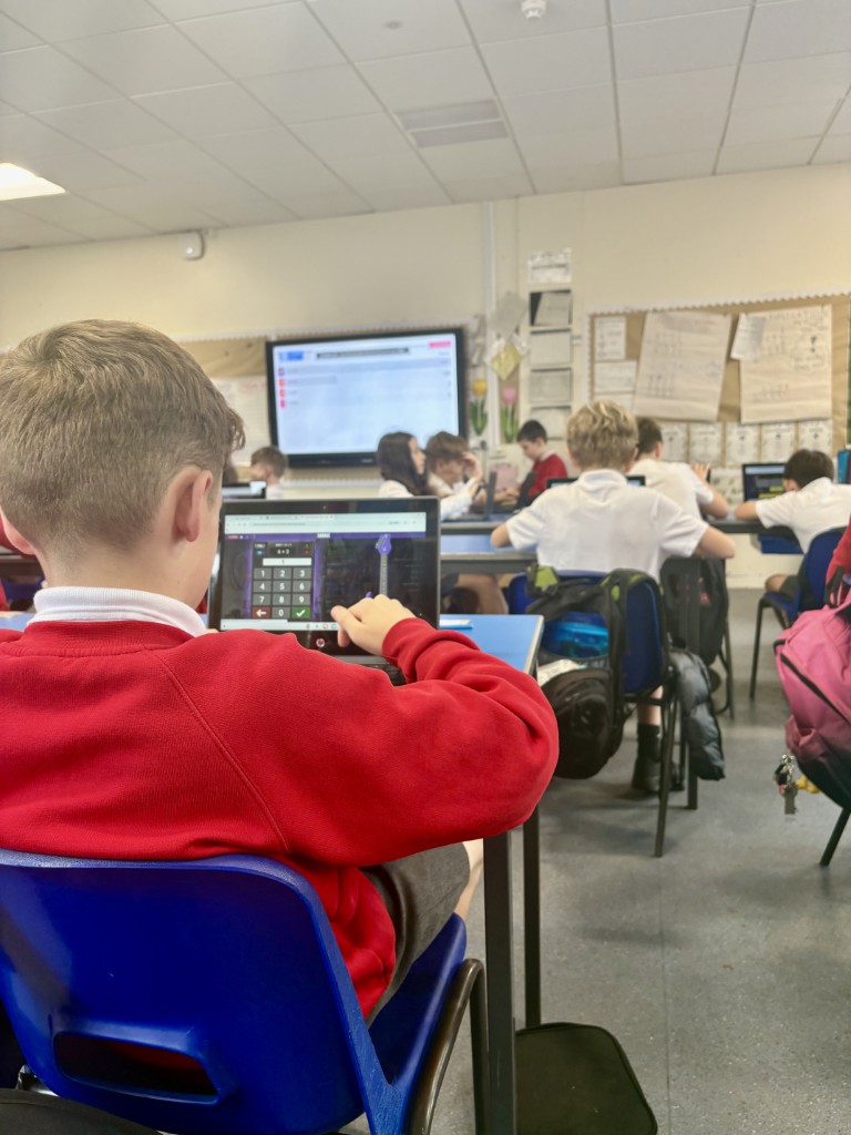Pupils using digital devices during a classroom lesson at Bridge of Weir Primary School
