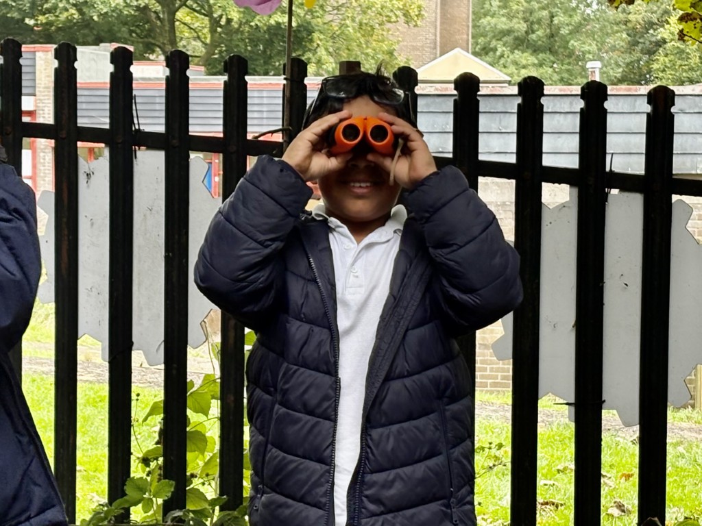 Pupil using binoculars during an outdoor learning activity at Bridge of Weir Primary School